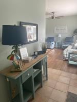 ein Wohnzimmer mit einem Schreibtisch mit einer Lampe in der Unterkunft Beautiful Two Bedroom, Two Bathroom First Floor Condo in Gulf Shores! in Gulf Shores