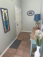 einen Flur mit einem Tisch und einem Bild an der Wand in der Unterkunft Beautiful Two Bedroom, Two Bathroom First Floor Condo in Gulf Shores! in Gulf Shores