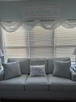 ein Sofa mit einem Kissen darauf im Wohnzimmer in der Unterkunft Beautiful Two Bedroom, Two Bathroom First Floor Condo in Gulf Shores! in Gulf Shores