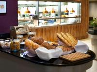 a tray of bread and pastries on a table at Novotel London West in London