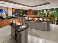 a restaurant with a counter with plates and food at Novotel London West in London