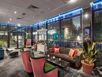 a lobby with a couch and tables and chairs at Novotel London West in London