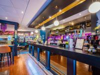 a bar with a long counter in a restaurant at Novotel London West in London