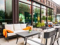 a patio with a couch and a table and chairs at Novotel London West in London