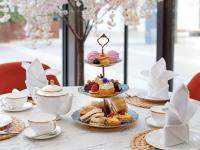 a table topped with plates of pastries and cups of tea at Novotel London West in London