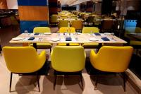 un comedor con sillas y mesas amarillas en Regenta Waterfront Resort, Dapoli, en Dapoli