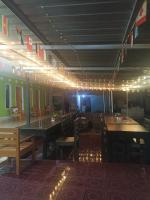 Un comedor con mesas, sillas y luces. en Oke rinjani, en Bayan