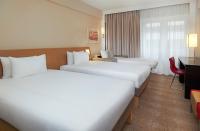 a hotel room with two beds and a desk at Novotel London West in London