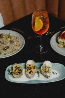 une table sur laquelle sont posées des assiettes de nourriture et une boisson dans l'établissement Quinto Hotel Boutique, à Guaymas