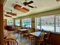 a dining room with tables and chairs and windows at Riverwalk Inn in Chelan