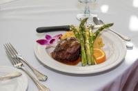 Un plato de carne y espárragos en una mesa. en Hilton Garden Inn Ocean City Oceanfront, en Ocean City