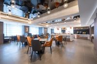 济南沃德酒店(济南凤鸣路鲍山地铁站店)的有桌椅和酒吧的餐厅