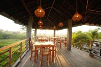 a restaurant with wooden tables and chairs on a deck at Goalie Beachfront Resort in Hikkaduwa