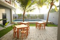 a patio with tables and chairs next to a pool at Goalie Beachfront Resort in Hikkaduwa