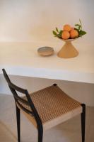 a chair sitting under a table with a bowl of oranges at Can Jaume by Ocean Drive in Ibiza Town