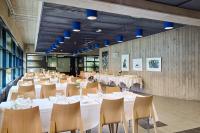 トゥルクにあるHotel Linnasmäkiの白いテーブルと椅子、青い照明が備わる宴会場