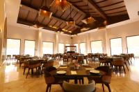 a dining room with tables and chairs and windows at Ananta Spa & Resort Jaipur in Jaipur