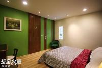 a bedroom with green walls and a bed and a chair at Good Time B&amp;B in Jiufen