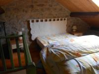 a bedroom with a bed in a stone wall at Gite du plô in La Cresse