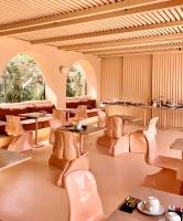 een grote kamer met stoelen, tafels en stoelen bij Hotiday Mykonos Fanari in Mykonos-stad