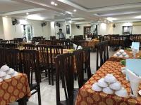 Un restaurante con mesas y sillas y un hombre al fondo. en Phong Lan Hotel Cửa Lò, en Thương Xà (2)