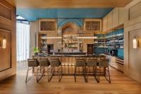 a kitchen with a bar with stools at JW Marriott Auckland in Auckland