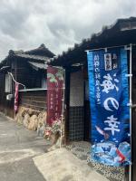 a building with signs on the side of it at 一日限定一組の古民家の宿なんでもん in Naoshima