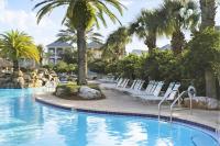 ein Pool in einem Resort mit Stühlen und Palmen in der Unterkunft The Bluefin - Luxury Beach Home! in Destin