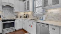 eine Küche mit weißen Schränken und einer Spüle in der Unterkunft The Bluefin - Luxury Beach Home! in Destin