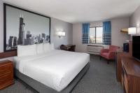 Una habitación de hotel con una cama blanca y un televisor. en Super 8 by Wyndham Romeoville Bolingbrook, en Romeoville