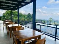 een restaurant met tafels en stoelen en uitzicht op het water bij Tebing View Glamping, Azana Hotels Collection in Tutugan