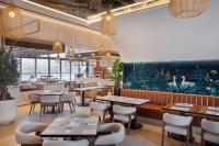 a restaurant with tables and chairs and a bar at Hotel Local Dubai, Jumeirah Village Triangle, Autograph Collection in Dubai