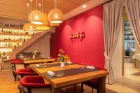 a restaurant with red walls and wooden tables and red chairs at Zoetry Mallorca Wellness & Spa in Llucmajor