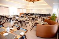 un ristorante con tavoli e sedie in legno e una caffetteria di Krishna Resort Pushkar a Pushkar