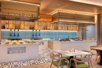 a large kitchen with tables and chairs in a restaurant at Home2 Suite by Hilton Fuyang Taihe in Fuyang