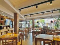 een restaurant met houten tafels en stoelen en ramen bij Hotel Toulon in Villa Carlos Paz