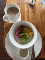 un tazón de comida y una taza de café sobre una mesa en Puri Sari Villas, Restaurant and Bar, en Nusa Lembongan