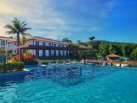 a swimming pool with chairs in front of a building at Resort QSB - Um novo padrão de conforto e lazer no coração da cidade in Pirenópolis
