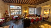 Logis Hôtel Restaurant Le Puits Doré في ريشيليو: مطعم به طاولات وكراسي في غرفة