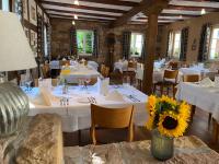 a dining room with white tables and chairs and flowers at Landhotel Hauer in Pleisweiler-Oberhofen