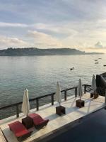 um deque com cadeiras e guarda-sóis junto à água em WALET PARADISE Ceningan Villa em Nusa Lembongan