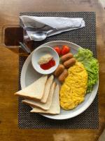 a plate of breakfast food with eggs sausage and toast at Katsetiu Villas in Kampong Telaga Papan