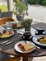 a table with plates of food and cups of coffee at Katsetiu Villas in Kampong Telaga Papan