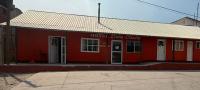 a red building with a sign on it at Hotel Doña Crucita in Creel