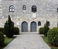 a stone building with two doors and some bushes at Divan in Plav