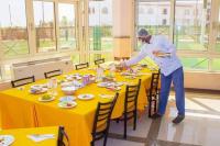 Un hombre de pie en una mesa con un plato de comida. en بيت الشباب الاسماعيلية, en Ismailía