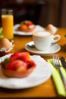 a table with plates of food and a cup of coffee at De Pingerhoeve in Nuth