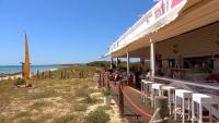 un gruppo di persone sedute sulla veranda di un ristorante sulla spiaggia di Villa Atalis 50 by Menorcarentals a Son Bou