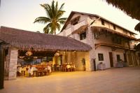 穆龙达瓦Hôtel Baobab Café的大楼前设有桌椅的餐厅