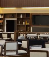 Un comedor con mesas y sillas y un televisor de pantalla plana. en Hangar Inn TJ - Aeropuerto, en Tijuana